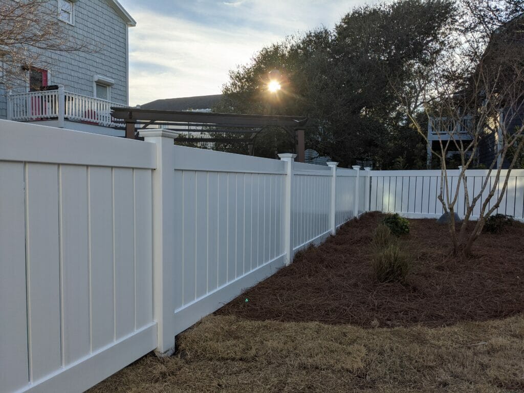 White vinyl privacy fence installed by Two Brothers Fencing in a residential backyard