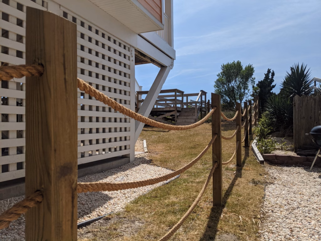 Post-and-rope fence with marine rope swagged between pressure-treated posts, installed by Two Brothers Fencing at a Carolina Beach cottage